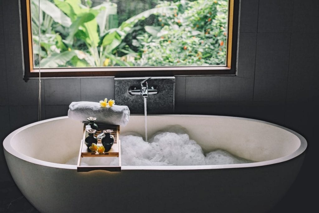 tips to make your bathroom cozier - a wooden bath tray